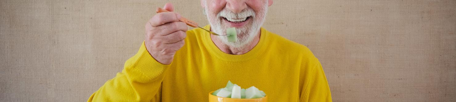 Foto oudere man met stoma die van zijn voeding geniet