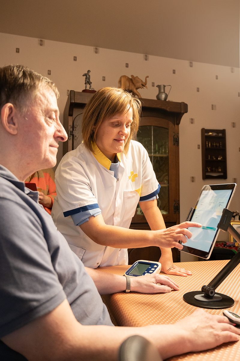 Verpleegkundige bekijkt samen met de patiënt de parameters op de tablet