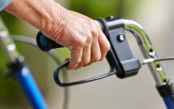 Oudere man wandelt met rollator