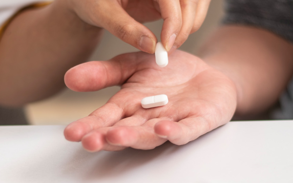 Verpleegkundige Wit-Gele Kruis geeft patiënt medicatie