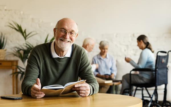 Foto oudere man die boek leest