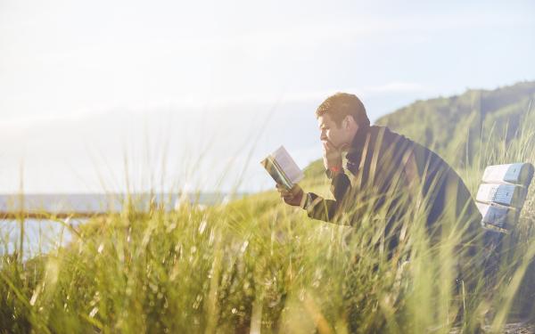 Man leest een boek op een bankje