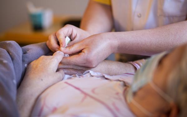 Thuisverpleegkundige Wit-Gele Kruis en patiënt