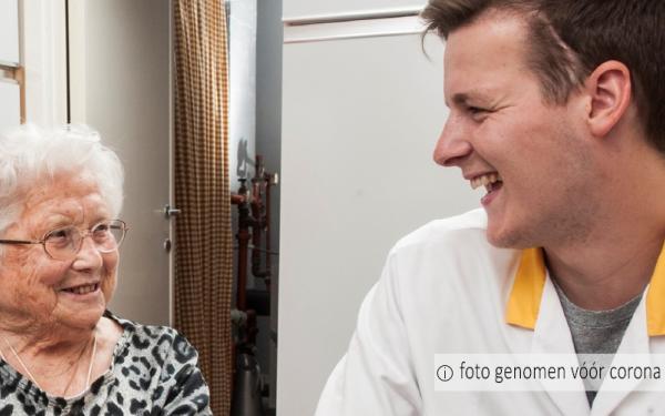 patiënt en thuisverpleegkundige lachen naar elkaar