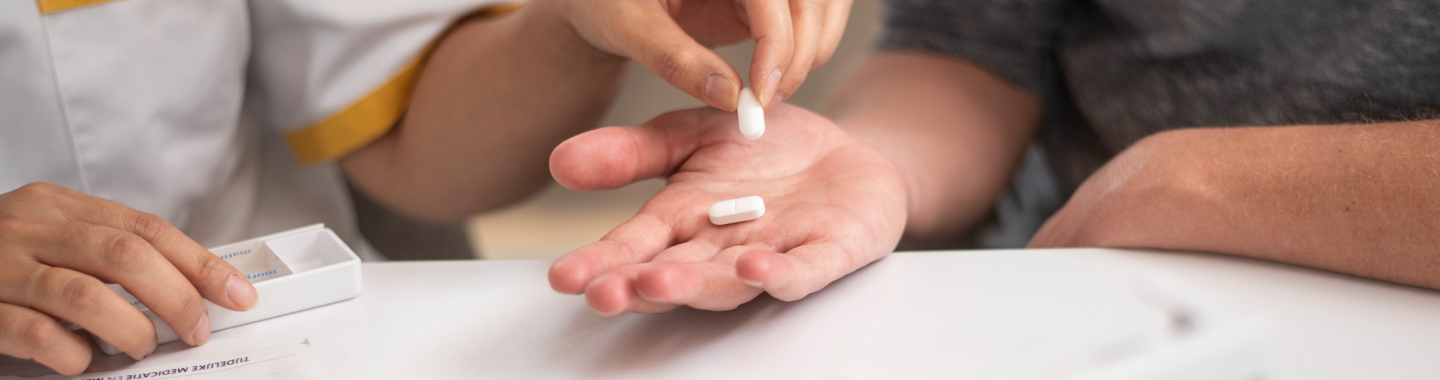 Verpleegkundige Wit-Gele Kruis geeft patiënt medicatie