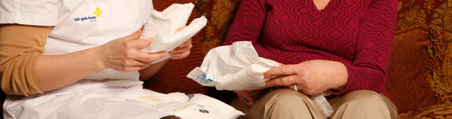 Verpleegkundige geeft incontinentiemateriaal aan patiënt