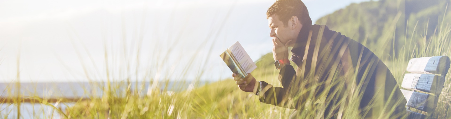 Man leest een boek op een bankje
