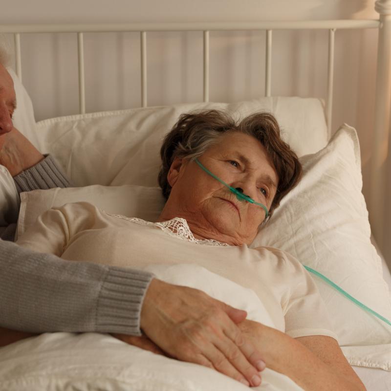 man aan het ziekenbed van een vrouw