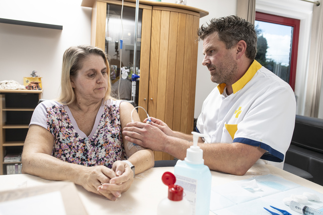 Foto verpleegkundige Wit-Gele Kruis bij patiënt met PICC-katheter