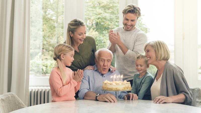 Familie viert de tachtigste verjaardag van opa met taart en het Personenalarm.