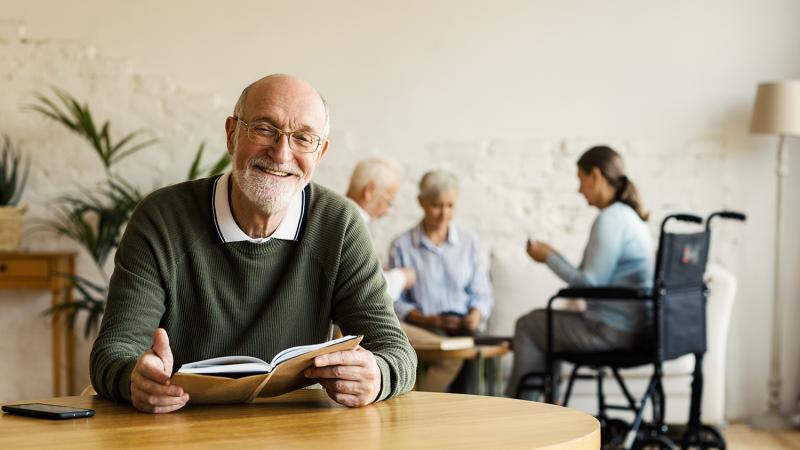 Foto oudere man die boek leest