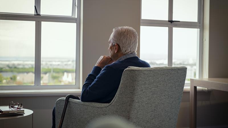 Foto man die uit raam kijkt