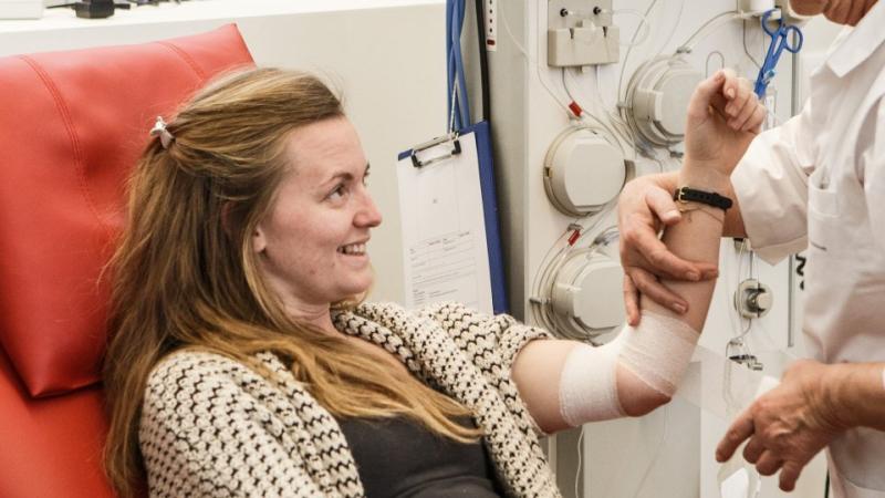 Jonge vrouw geeft bloed in donorcentrum Rode Kruis